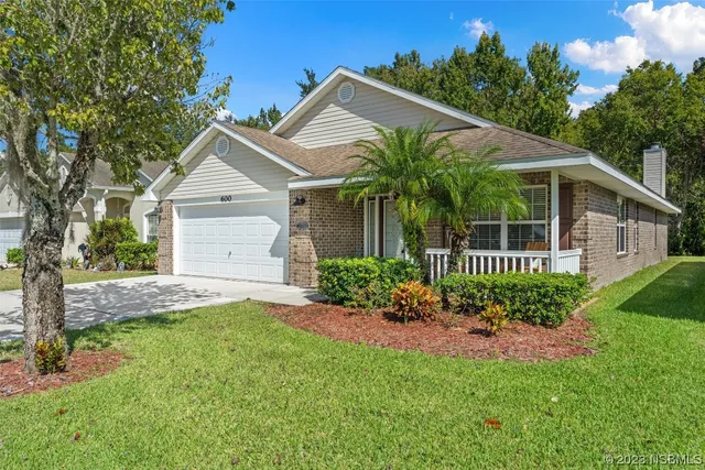 a front view of a house with a garden and plants