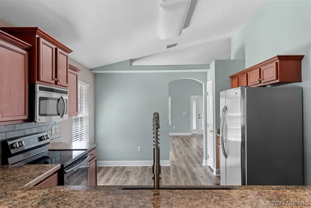 a kitchen with stainless steel appliances granite countertop a sink and refrigerator