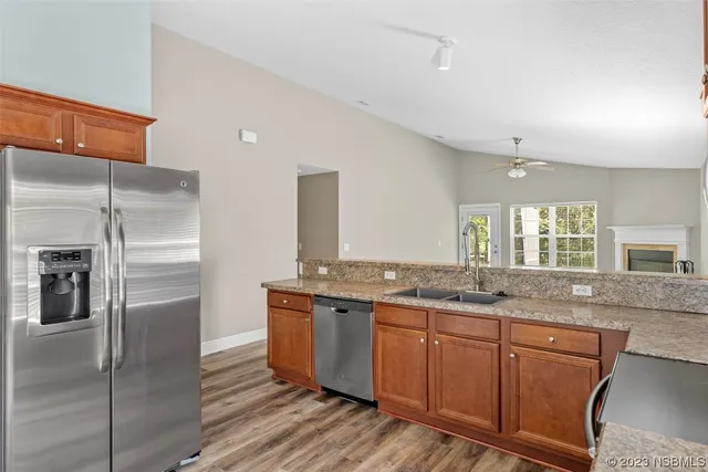 a kitchen with stainless steel appliances granite countertop a refrigerator and a sink