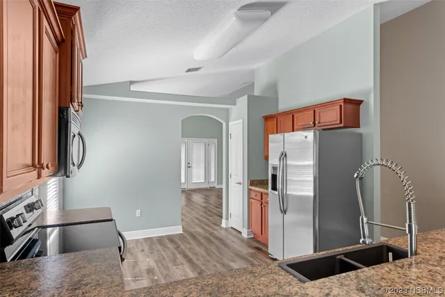 a view of kitchen and hall with wooden floor