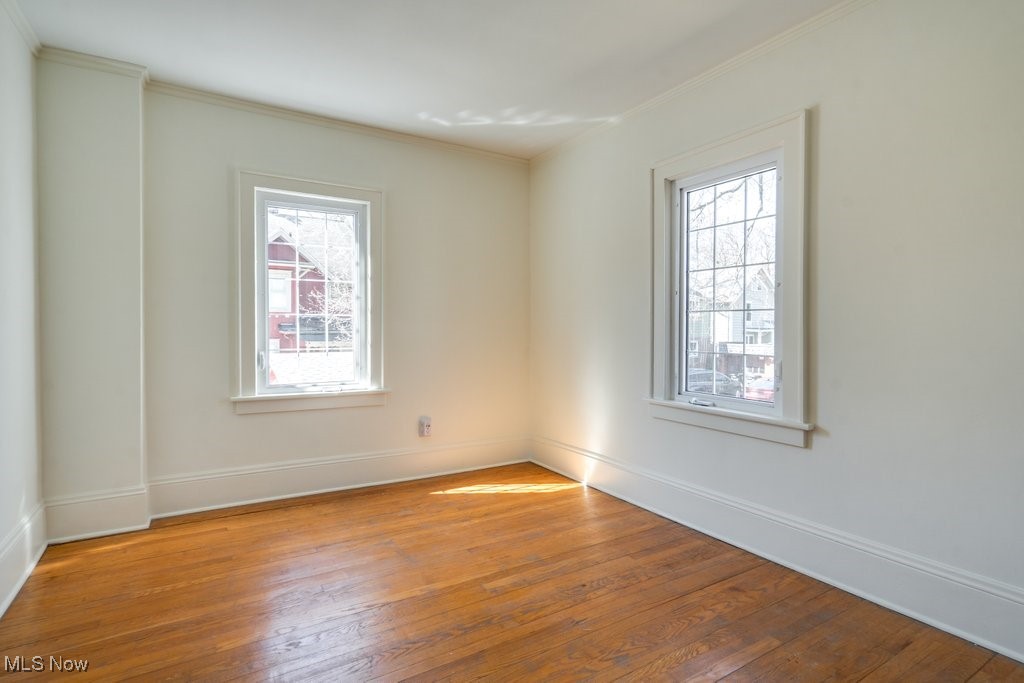 199 Edgerton Road Akron, OH 44303 - Photo 39 of 49 Empty room featuring a wealth of natural light, ornamental molding, and wood-type flooring