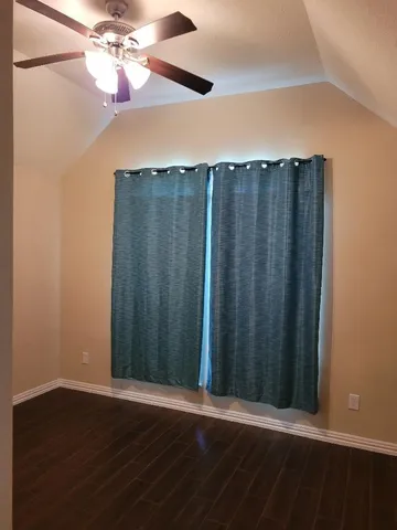 a view of a room with wooden floor and fan