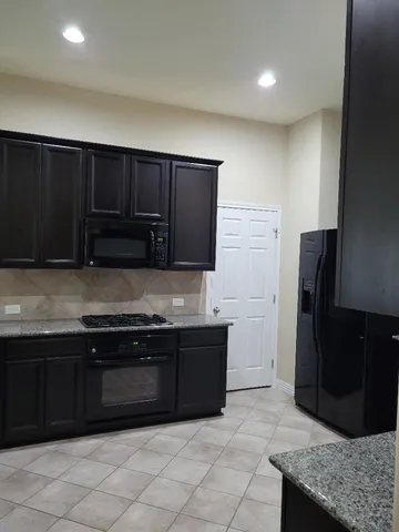 a kitchen with stainless steel appliances granite countertop a refrigerator and a sink