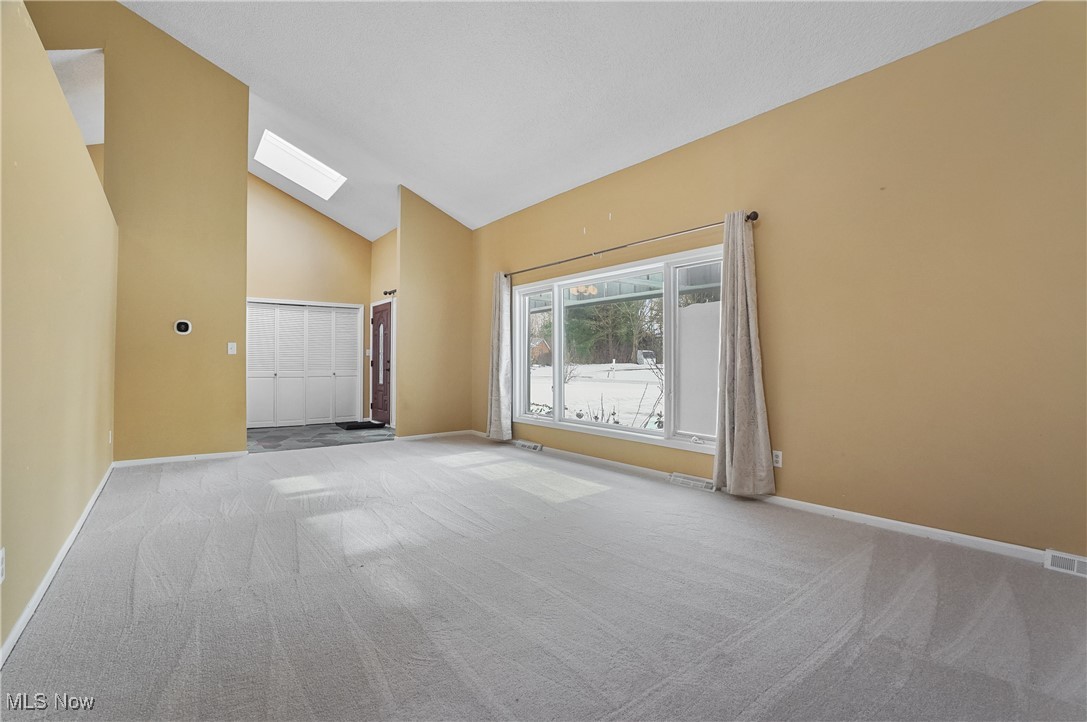 1094 San Raphael Drive Akron, OH 44333 - Photo 10 of 50 Carpeted spare room featuring high vaulted ceiling and a skylight
