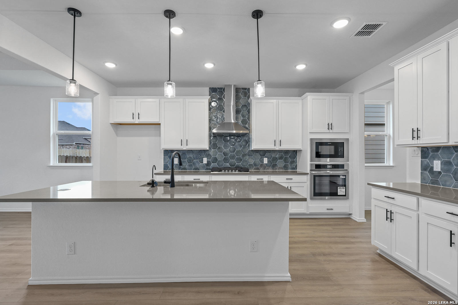 7432 Cremorne Converse, TX 78109 - Photo 11 of 35 a large kitchen with kitchen island a stove a sink a center island and cabinets