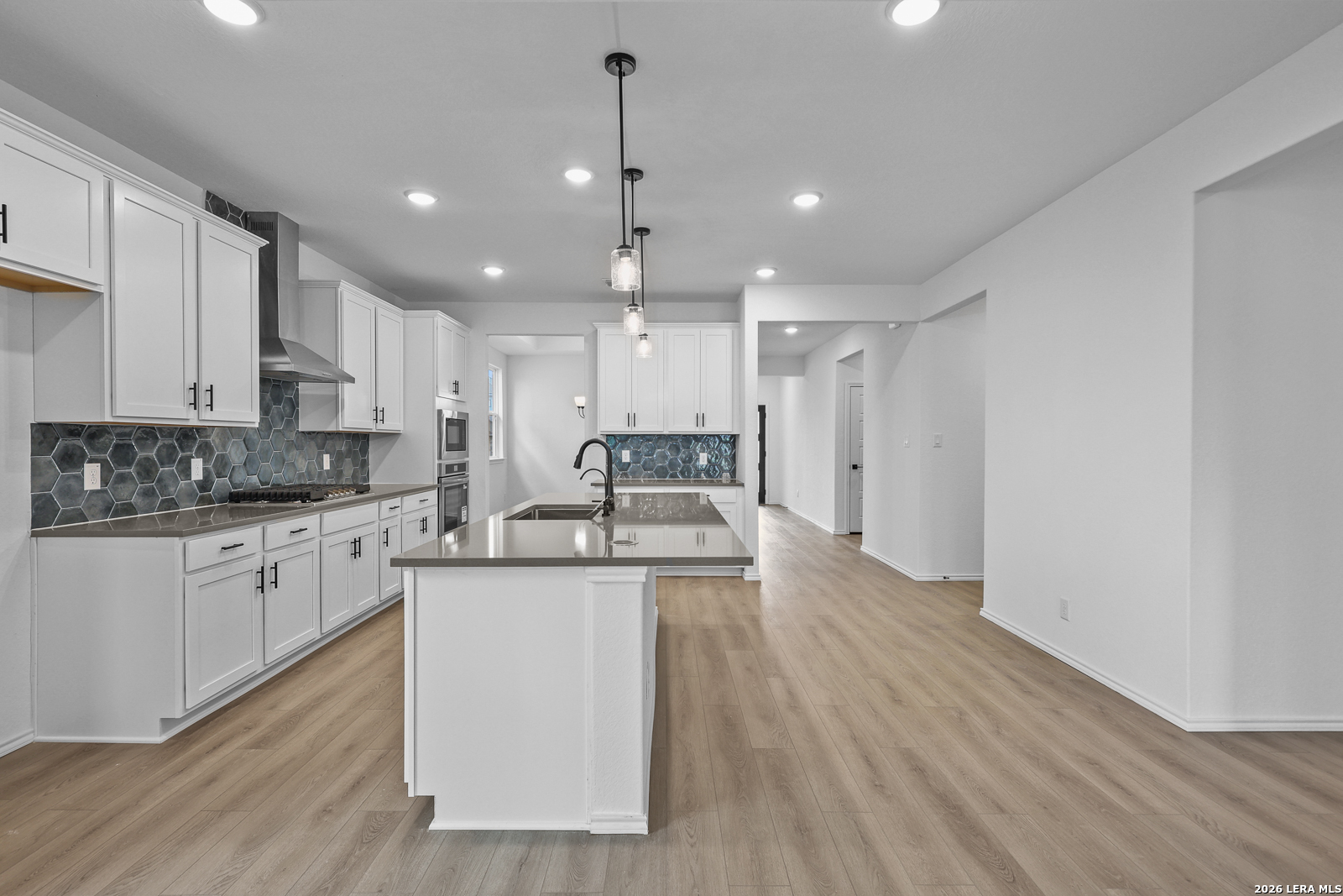 7432 Cremorne Converse, TX 78109 - Photo 13 of 35 a large kitchen with stainless steel appliances granite countertop a stove a sink and white cabinets with wooden floor