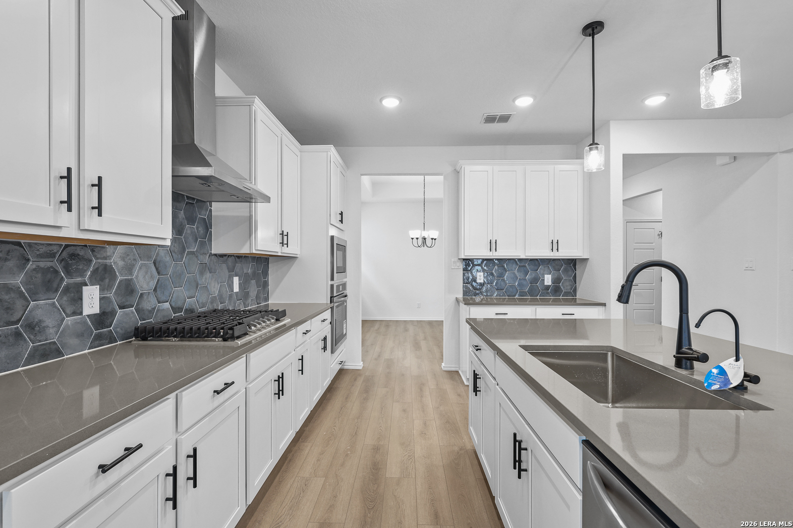 7432 Cremorne Converse, TX 78109 - Photo 14 of 35 a kitchen with stainless steel appliances granite countertop a sink a stove and a wooden floors