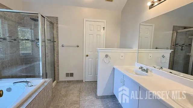 a bathroom with a tub sink and mirror