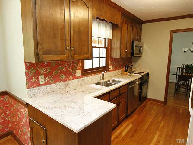 8904 Jeanew Court Raleigh, NC 27613 - Photo 5 of 25 Plenty of food preparation space for all your cooking needs. This kitchen has an abundance of cabinets and a separate pantry! The kitchen has beautiful granite countertops,hardwood floors, and a stainless sink, dishwasher and microwave. Kitchen