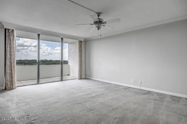 a view of an empty room with wooden floor and stairs