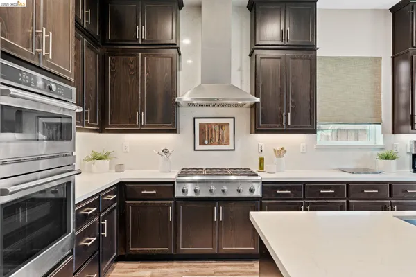 a kitchen with granite countertop a refrigerator stove and sink