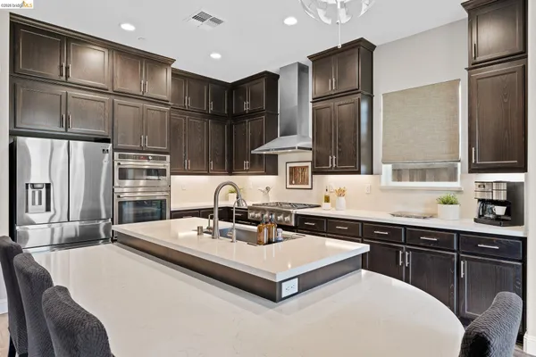 a kitchen with stainless steel appliances a sink and a refrigerator