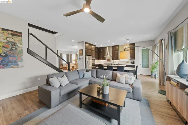 a living room with furniture kitchen view and a large window