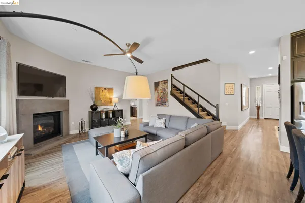 a living room with furniture kitchen view and a large window