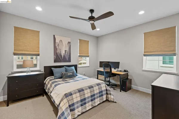 a bedroom with a bed and a flat tv screen on wall