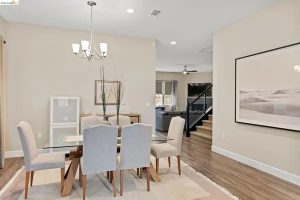 a view of a dining room with furniture a chandelier and wooden floor