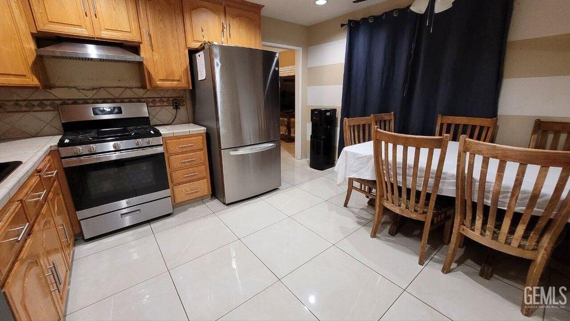 Undisclosed Address Bakersfield, CA 93309 - Photo 4 of 8 a kitchen with stainless steel appliances a stove a refrigerator and a fireplace