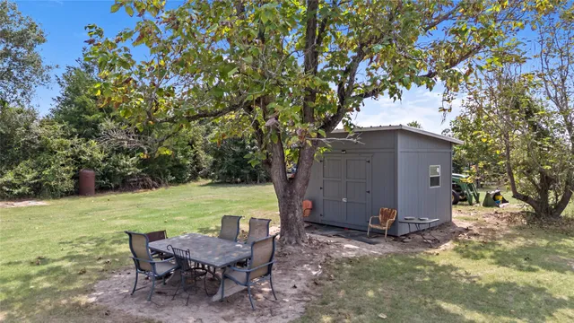 a view of a house with a big yard and a large tree