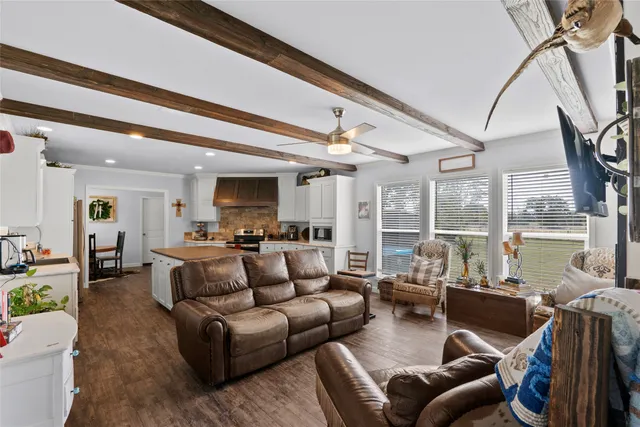 a living room with furniture a large window and a flat screen tv