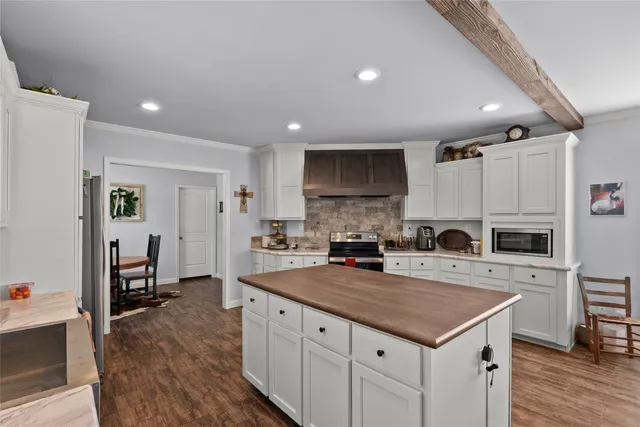 a kitchen with a sink a stove a refrigerator cabinets and wooden floor