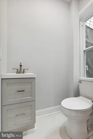 a bathroom with a sink a toilet and a window