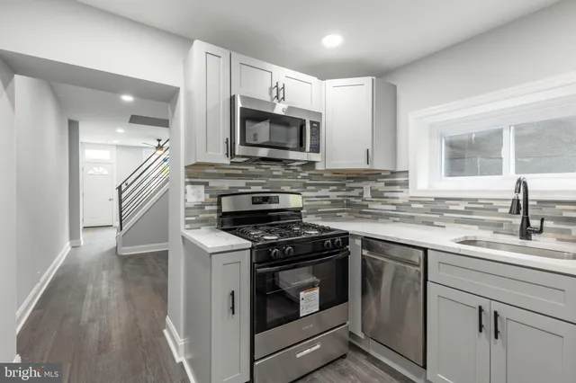 a kitchen with stainless steel appliances granite countertop a sink and a stove top oven