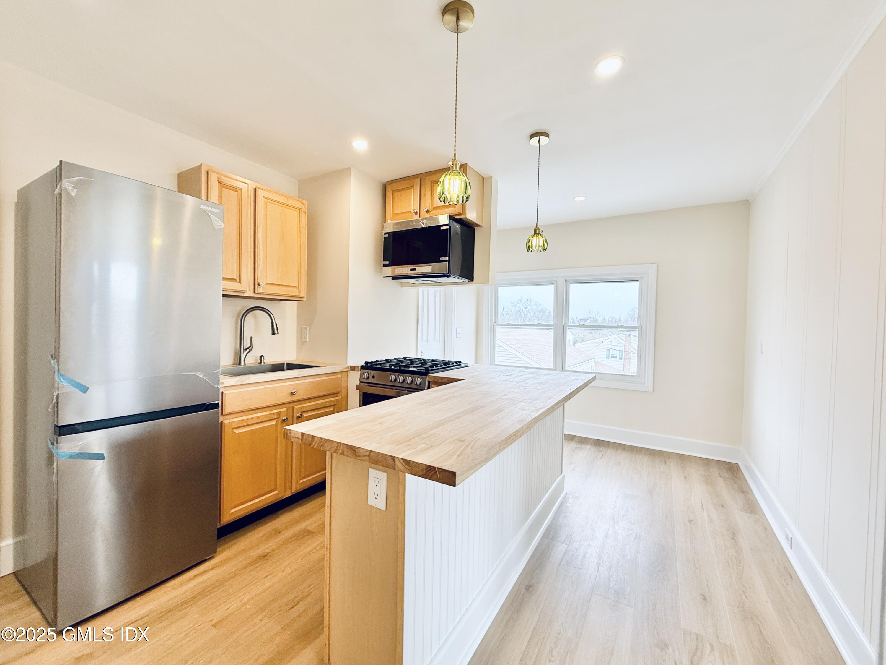 237 Hamilton Avenue, Unit 2 Greenwich, CT 06830 - Photo 3 of 20 a kitchen with stainless steel appliances granite countertop a refrigerator a sink and a stove