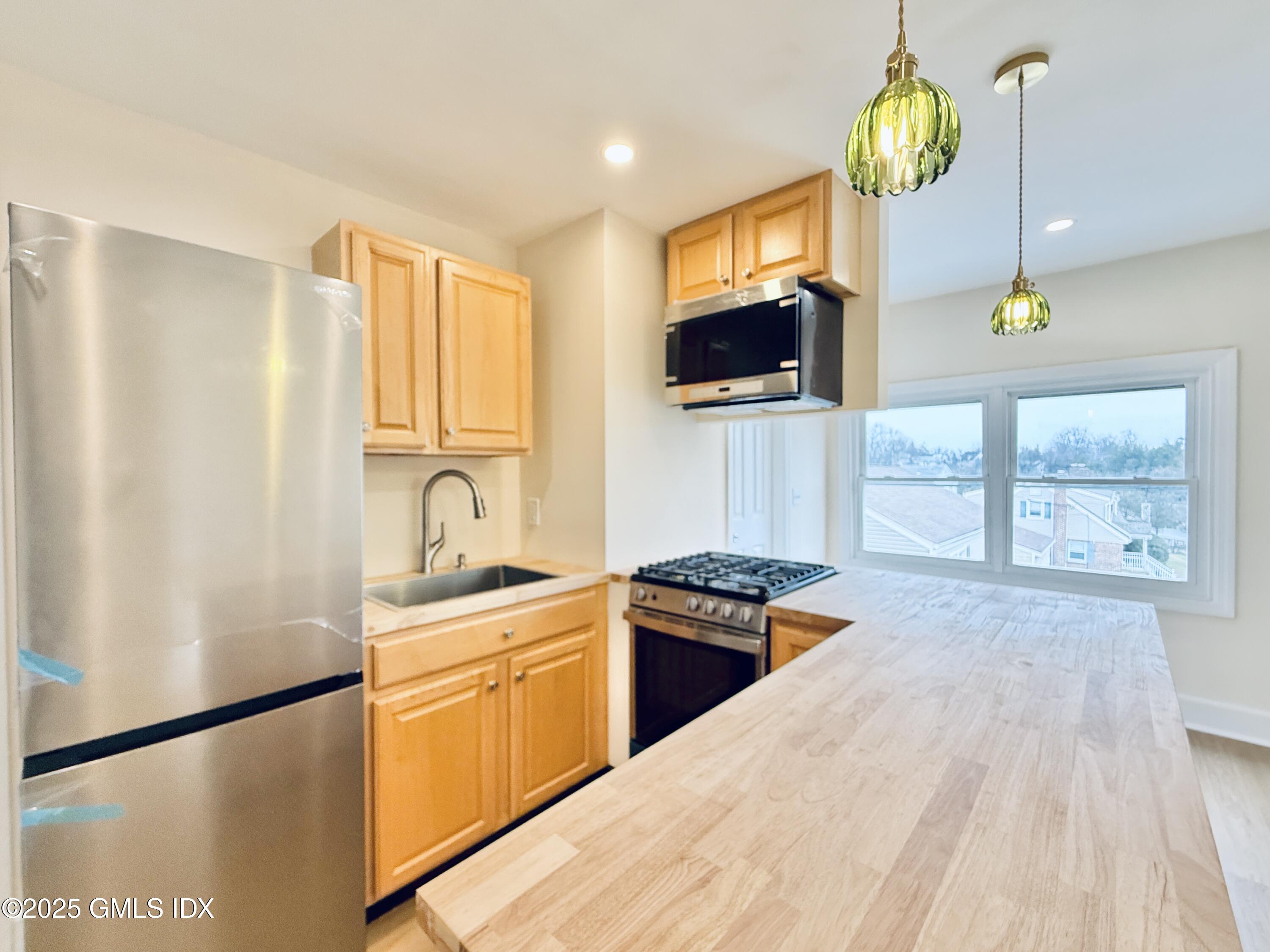 237 Hamilton Avenue, Unit 2 Greenwich, CT 06830 - Photo 7 of 20 a kitchen with stainless steel appliances granite countertop a sink stove and microwave