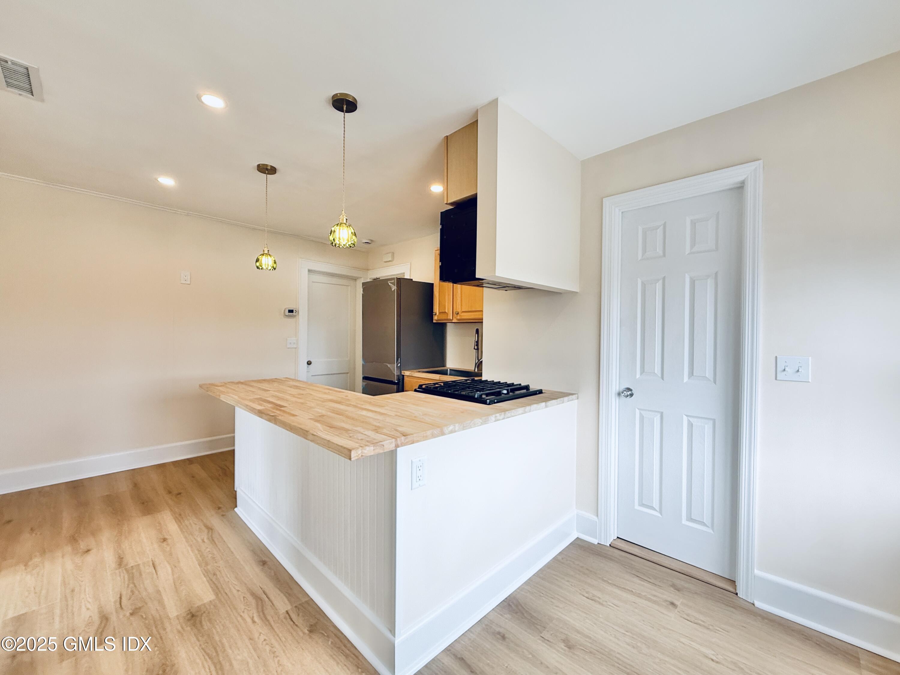 237 Hamilton Avenue, Unit 2 Greenwich, CT 06830 - Photo 8 of 20 a kitchen with stainless steel appliances granite countertop a sink stove and wooden floor