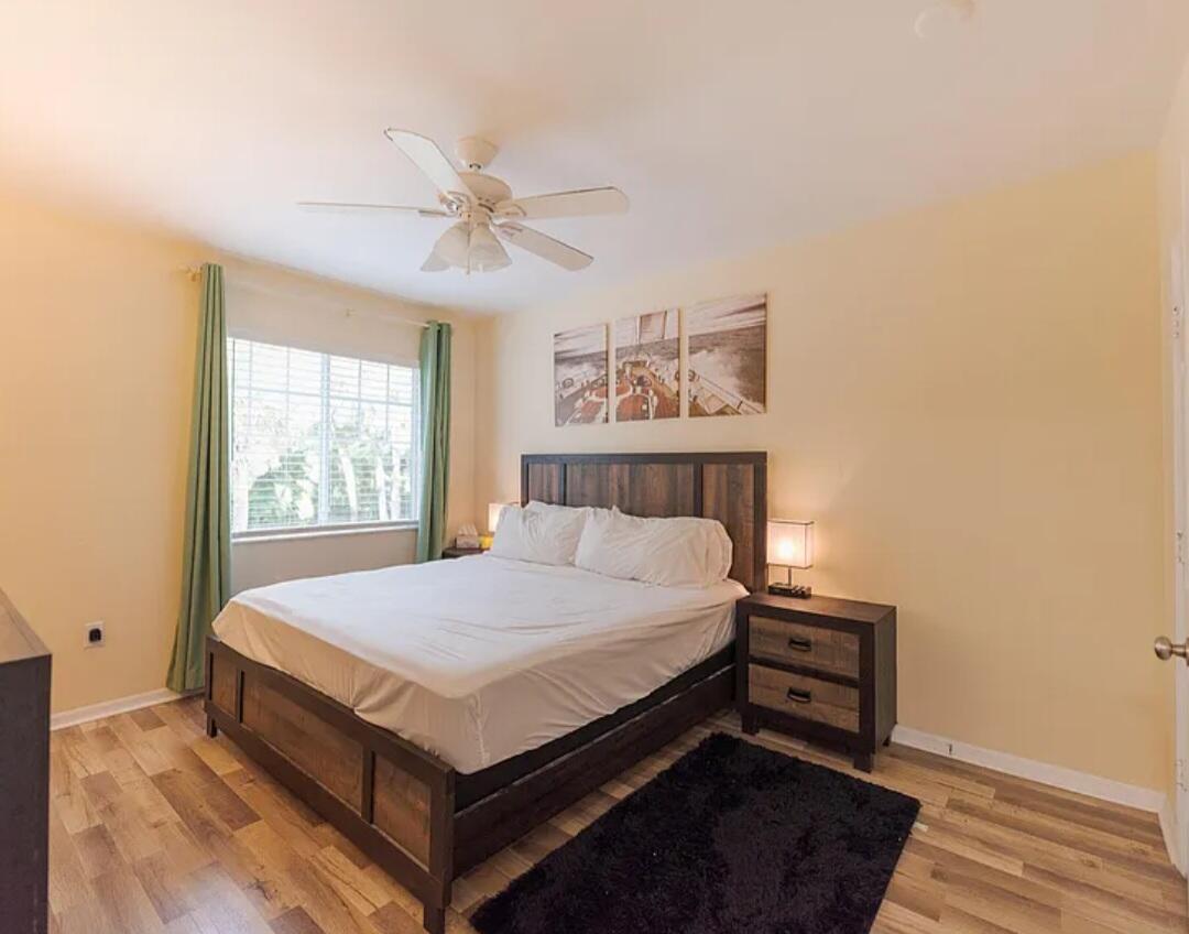 6556 Emerald Dunes Drive, Unit 207 West Palm Beach, FL 33411 - Photo 10 of 11 a bed sitting in a bedroom next to a window