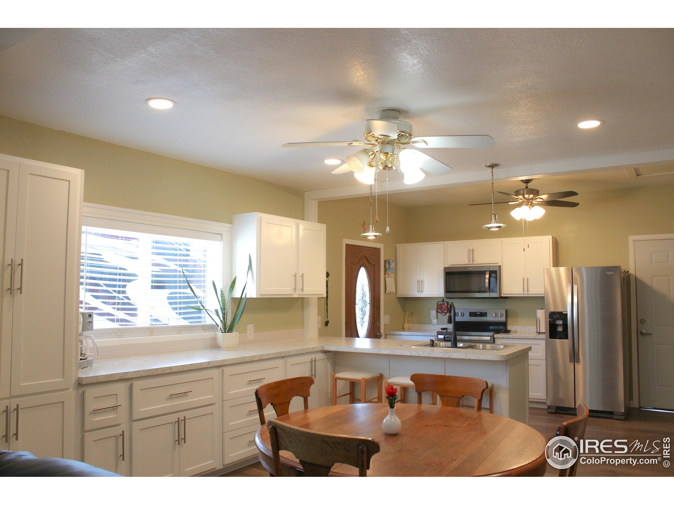 504 12th Street Greeley, CO 80631 - Photo 3 of 19 a kitchen with kitchen island granite countertop a sink cabinets and stainless steel appliances