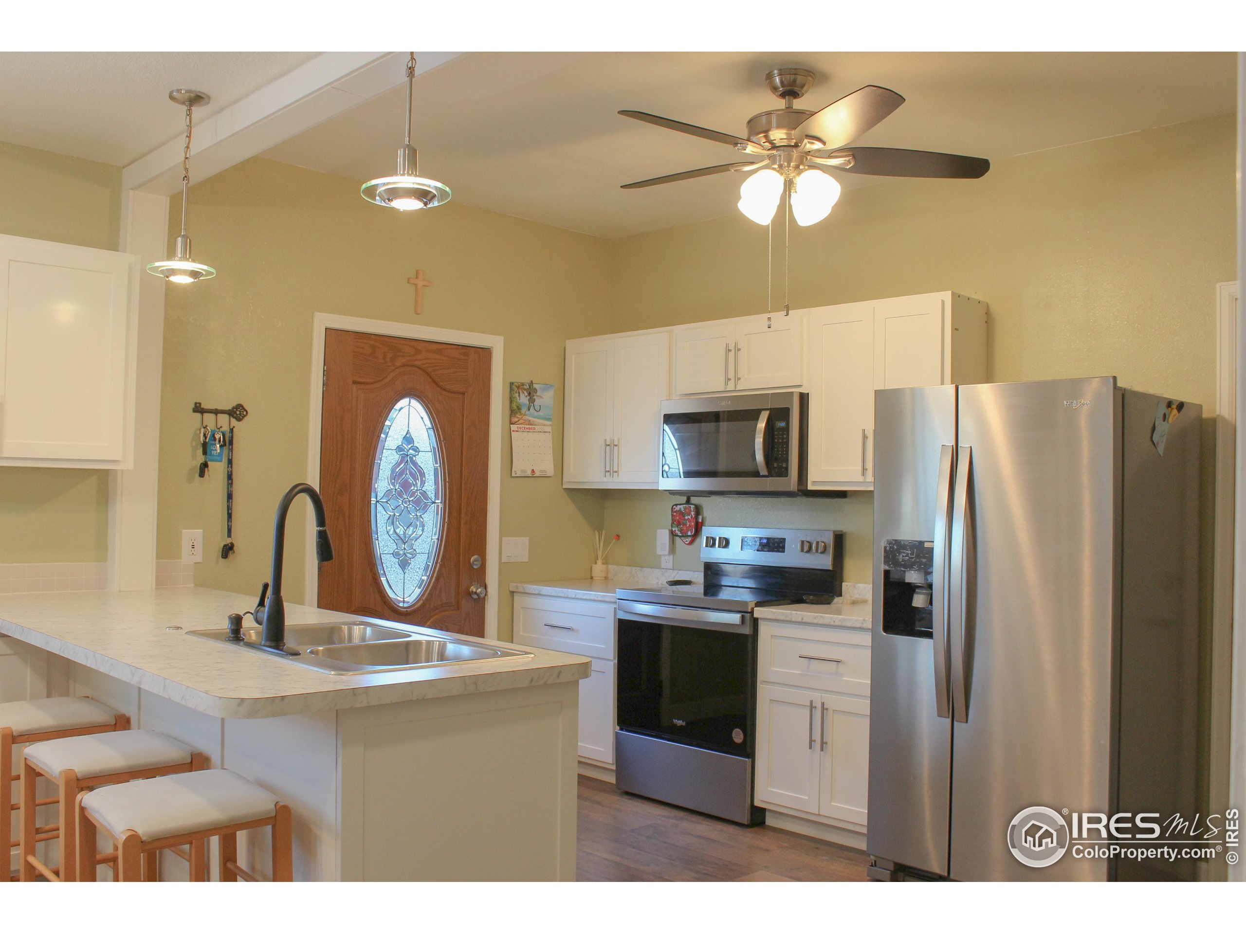 504 12th Street Greeley, CO 80631 - Photo 4 of 19 a kitchen with kitchen island a refrigerator a sink and a stove