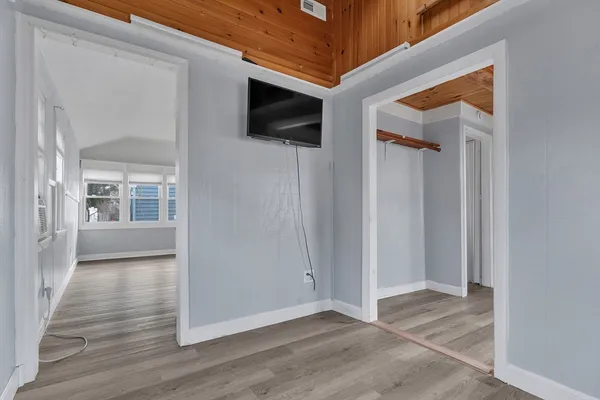 a view of a hallway with wooden floor and a living room