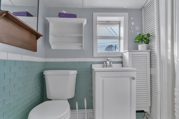 a bathroom with a toilet sink and mirror