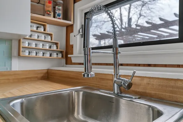 a kitchen with a sink and large mirror