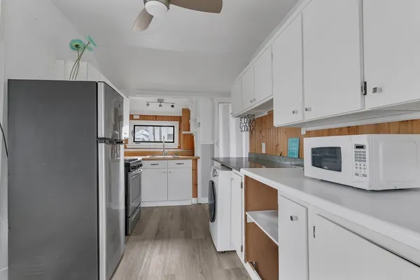 a kitchen with a refrigerator sink and cabinets