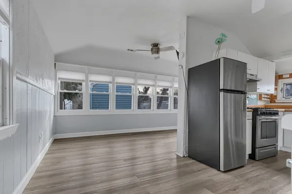 a view of a kitchen with wooden floor and electronic appliances