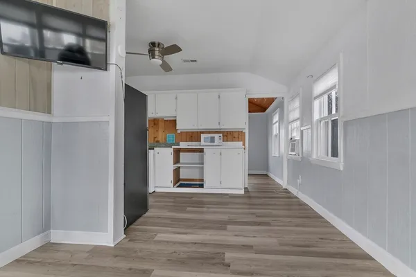 a view of a kitchen with wooden floor and electronic appliances