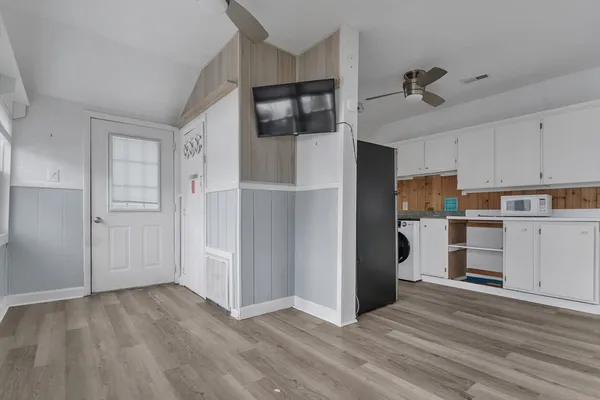 a view of kitchen with wooden floor and electronic appliances