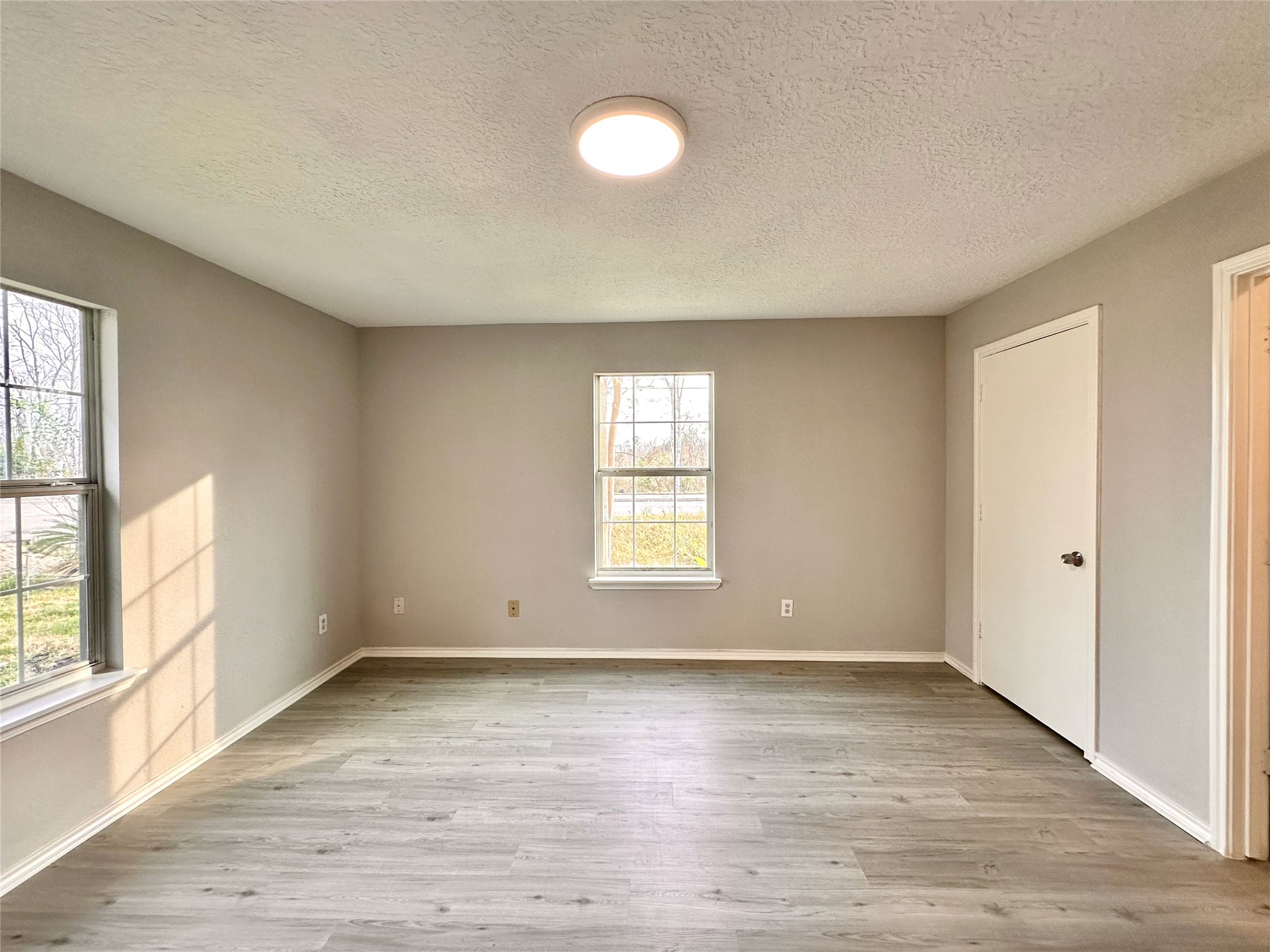 15134 Alkay Street Houston, TX 77053 - Photo 13 of 25 an empty room with wooden floor and windows