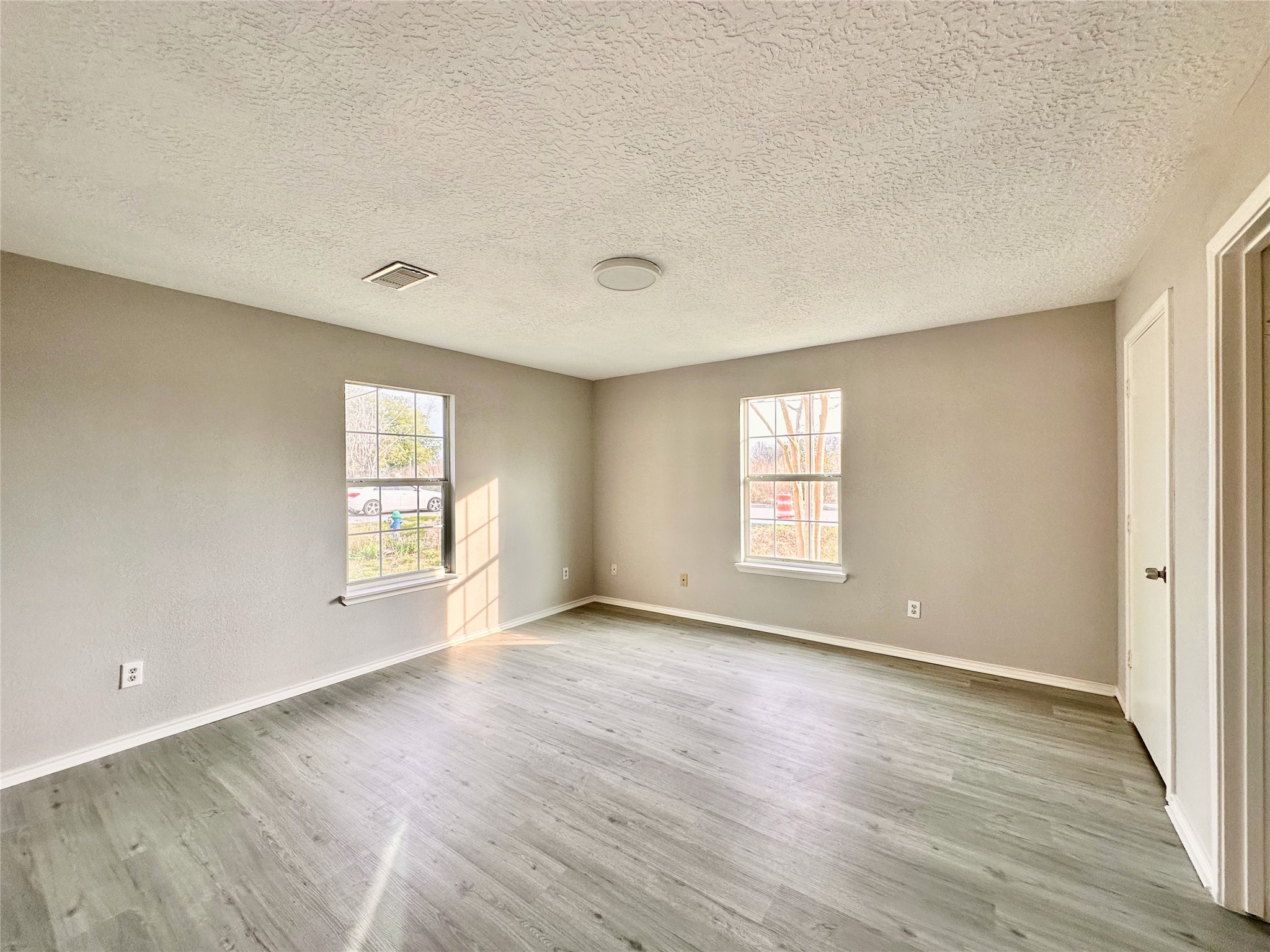 15134 Alkay Street Houston, TX 77053 - Photo 14 of 25 an empty room with wooden floor and windows