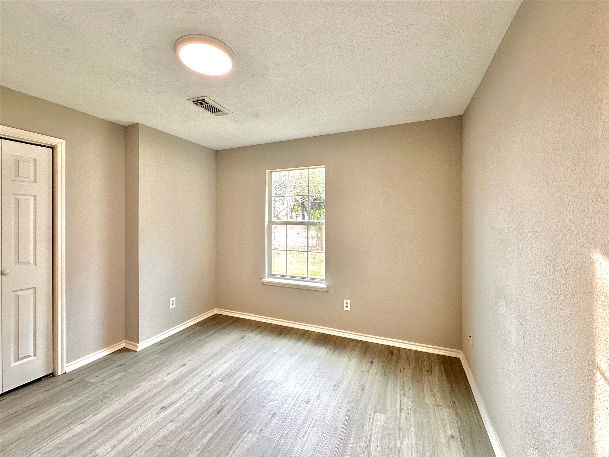 15134 Alkay Street Houston, TX 77053 - Photo 16 of 25 an empty room with wooden floor and windows