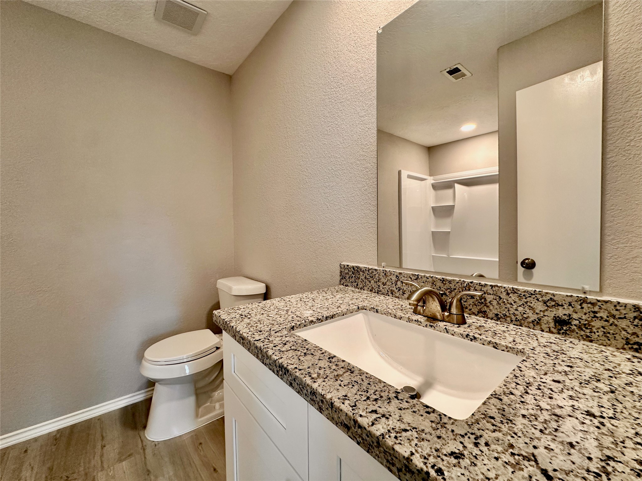 15134 Alkay Street Houston, TX 77053 - Photo 20 of 25 a bathroom with a granite countertop sink a toilet and a mirror