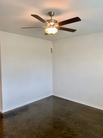 an empty room with a chandelier fan