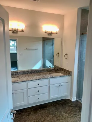 a bathroom with a granite countertop sink and a mirror