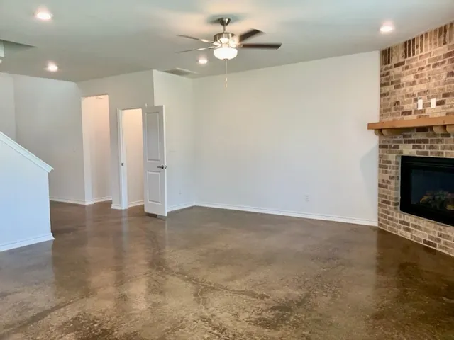 an empty room with windows and fireplace
