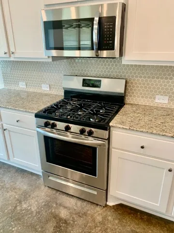 a stove top oven sitting inside of a kitchen