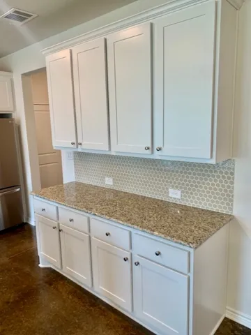 a kitchen with granite countertop white cabinets and sink