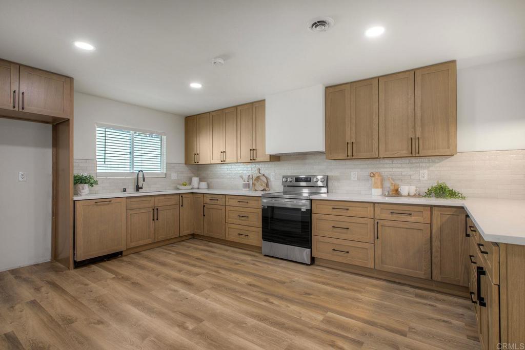 728 Hackberry Place Fallbrook, CA 92028 - Photo 7 of 23 a large kitchen with granite countertop white cabinets and white stainless steel appliances