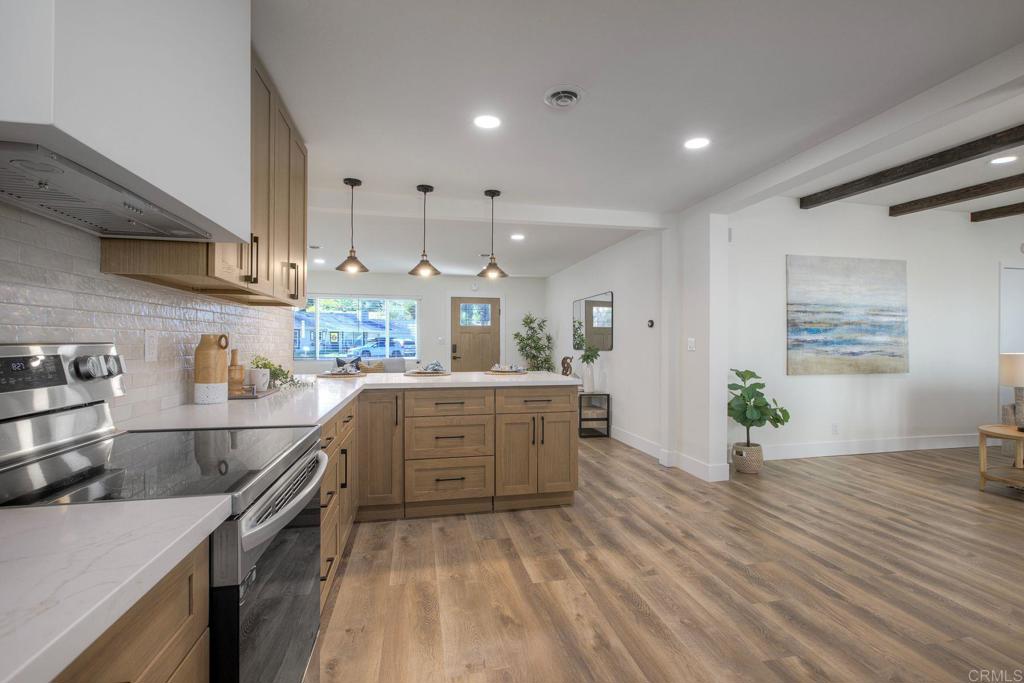 728 Hackberry Place Fallbrook, CA 92028 - Photo 8 of 23 a kitchen with stainless steel appliances kitchen island hardwood floor sink and stove